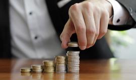 closeup-shot-businessman-s-hands-counting-stacks-coins-after-business-success.jpg