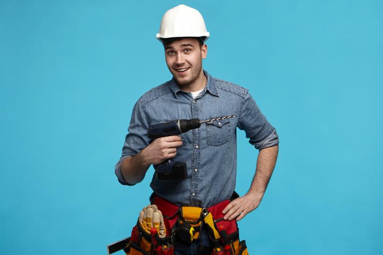 studio-shot-positive-friendly-young-constructor-carrying-drill-belt-with-all-instruments-doing-renovation-client (1).jpg