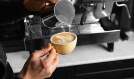 close-up-hand-pouring-milk-delicious-coffee-cup.jpg