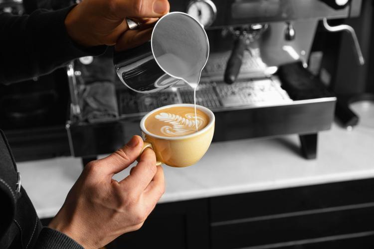 close-up-hand-pouring-milk-delicious-coffee-cup.jpg