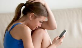woman-crying-while-reading-message-on-cellphone.jpg