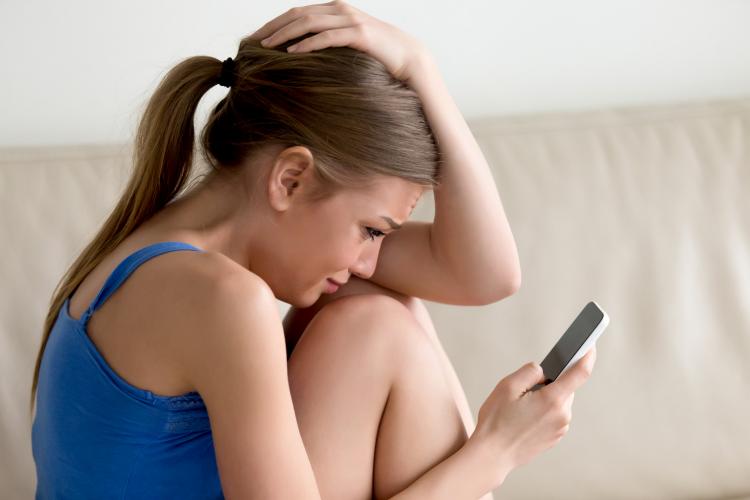 woman-crying-while-reading-message-on-cellphone.jpg