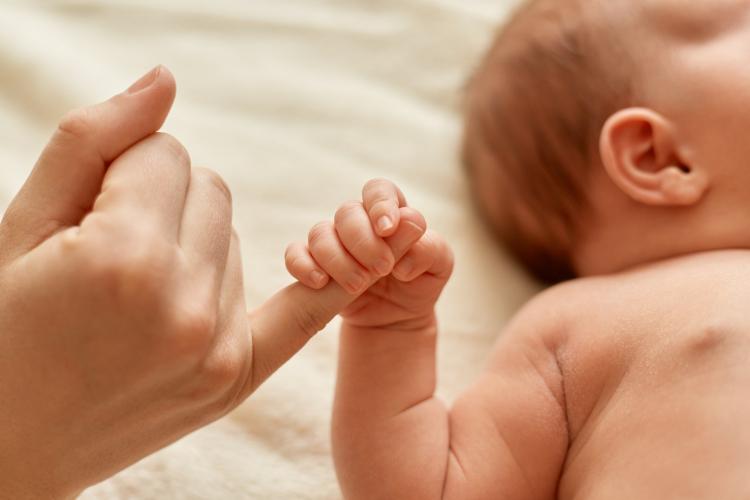 faceless-mother-with-naked-baby-infant-holding-mommy-s-finger-mum-spending-time-with-her-tiny-child-on-light-background.jpg