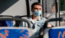 young-man-travelling-by-city-bus-wearing-surgical-mask.jpg