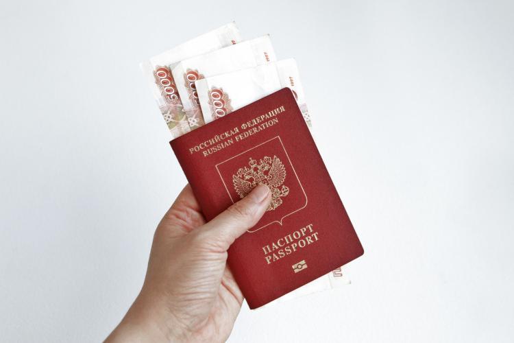 hand-holding-russian-passport-with-5000-rubles-banknotes.jpg