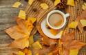 closeup-shot-of-a-cup-of-coffee-and-autumn-leaves-on-wooden-surface.jpg