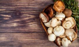 top-view-of-fresh-mushrooms-in-a-wicker-basket-on-rustic-wood-with-copy-space.jpg