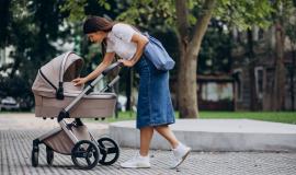 young-mother-walking-with-baby-stroller-in-park.jpg