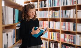 teen-girl-among-pile-books-young-girl-reads-book-with-shelves-background-she-is-surrounded-by-stacks-books-book-day.jpg