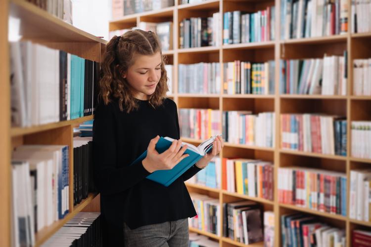 teen-girl-among-pile-books-young-girl-reads-book-with-shelves-background-she-is-surrounded-by-stacks-books-book-day.jpg