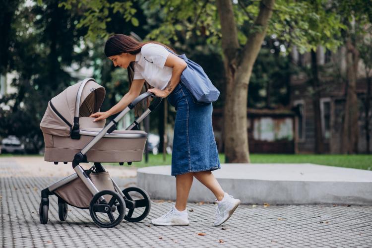 young-mother-walking-with-baby-stroller-in-park.jpg