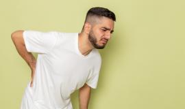 a-front-view-young-male-in-white-t-shirt-having-severe-back-ache.jpg