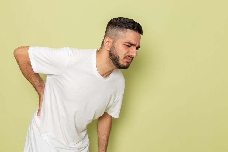 a-front-view-young-male-in-white-t-shirt-having-severe-back-ache.jpg