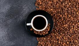 top-view-coffee-cup-and-coffee-beans-on-dark-table.jpg