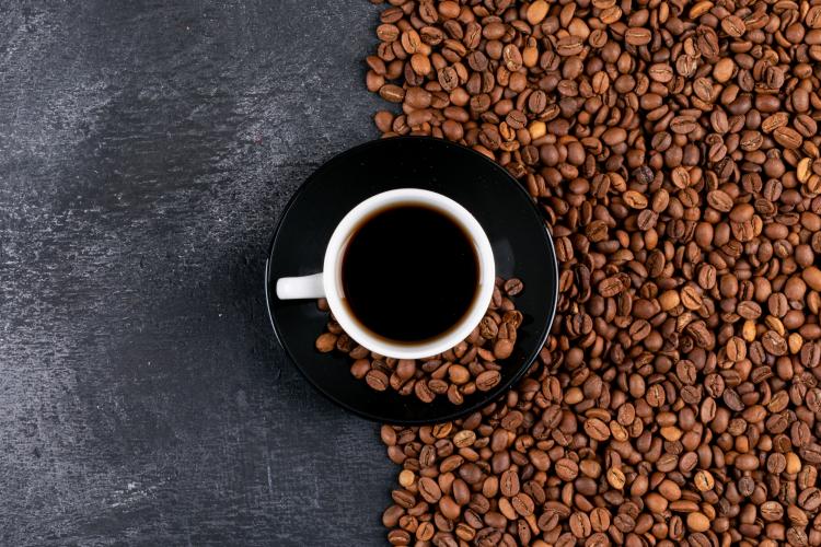 top-view-coffee-cup-and-coffee-beans-on-dark-table.jpg