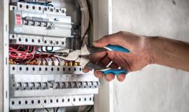 an-electrical-technician-working-in-a-switchboard-with-fuses.jpg