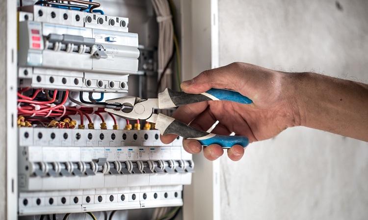 an-electrical-technician-working-in-a-switchboard-with-fuses.jpg