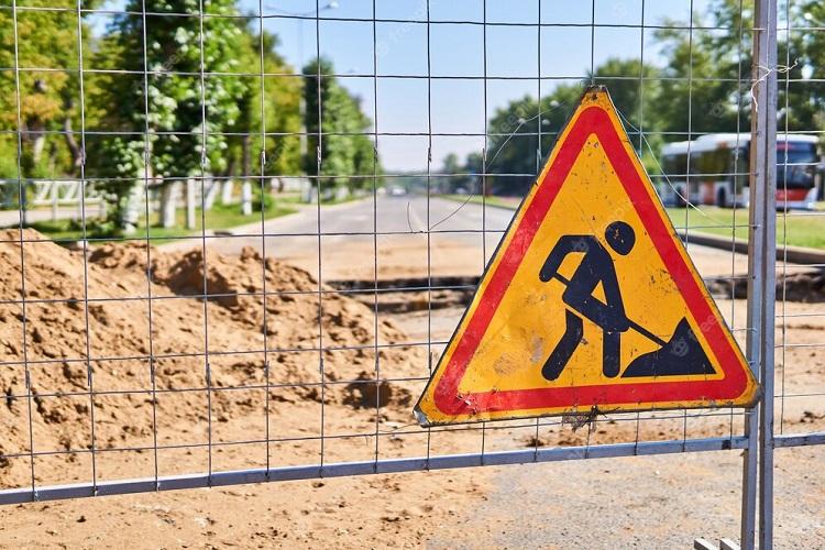 road-sign-roadworks-ahead-on-the-fence-against-the-background-of-a-trench-across-an-empty-street_533998-3392.jpg