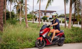 tattooed-strong-man-on-tropical-jungle-field-with-red-motorbike.jpg