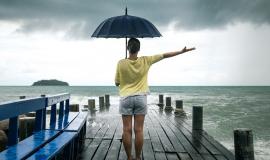 young-girl-on-pier-with-umbrella-stands-with-his-back-to-the-sea.jpg