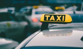 selective-focus-shot-of-a-yellow-taxi-sign-in-a-traffic-jam_181624-42635.jpg