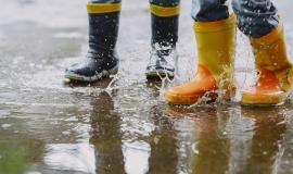 funny-kids-in-rain-boots-playing-with-paper-ship-by-a-puddle.jpg