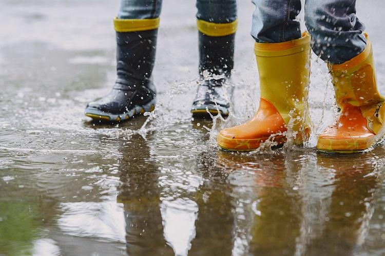 funny-kids-in-rain-boots-playing-with-paper-ship-by-a-puddle.jpg