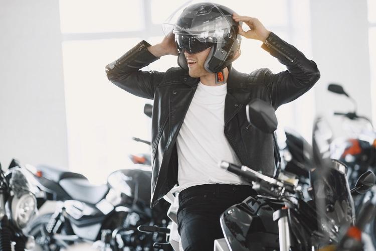 man-choosed-motorcycles-in-moto-shop-guy-in-a-black-jacket-man-in-a-helmet.jpg