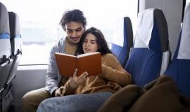 couple-reading-a-book-while-traveling-by-train.jpg