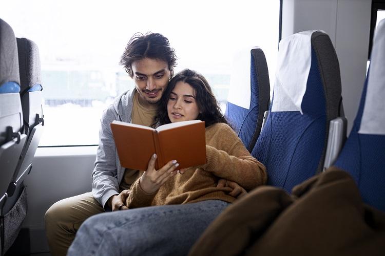 couple-reading-a-book-while-traveling-by-train.jpg