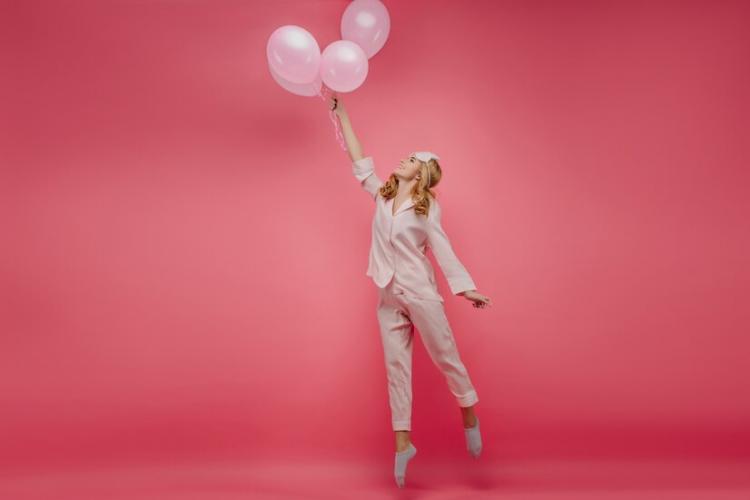 full-length-portrait-lovely-carefree-girl-standing-tip-toes-with-balloons-indoor-photo-curly-lady-pink-sleepwear-eyemask-jumping-with-smile_197531-21642.jpg