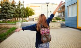 stdent-girl-with-a-backpack-walking-on-the-street.jpg