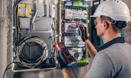 man-an-electrical-technician-working-in-a-switchboard-with-fuses.jpg