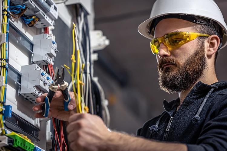 a-male-electrician-works-in-a-switchboard-with-an-electrical-connecting-cable.jpg
