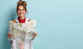 positive-smiling-young-female-tourist-searches-for-inspiring-places-holds-paper-map-finds-new-sightseeing-for-discovering_273609-25656.jpg