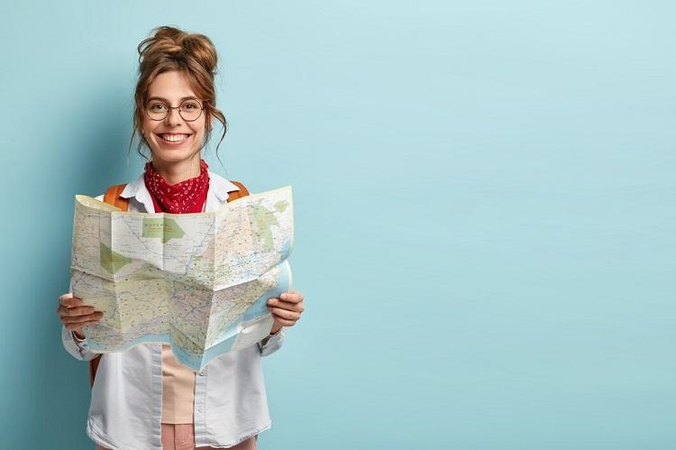 positive-smiling-young-female-tourist-searches-for-inspiring-places-holds-paper-map-finds-new-sightseeing-for-discovering_273609-25656.jpg