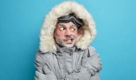 photo-european-man-trembles-from-cold-after-going-skateboarding-crosses-hands-body-tries-warm-himself-wears-grey-winter-jacker-with-fur-hood-gloves-has-frozen-face-covered-by-ice_273609-47043.jpg