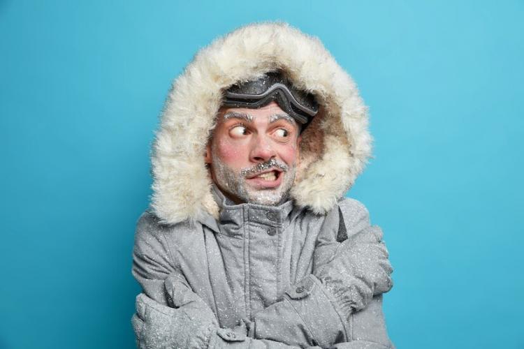 photo-european-man-trembles-from-cold-after-going-skateboarding-crosses-hands-body-tries-warm-himself-wears-grey-winter-jacker-with-fur-hood-gloves-has-frozen-face-covered-by-ice_273609-47043.jpg