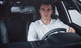 young-man-sits-newly-bought-car-holding-his-hands-rudder_146671-14762.jpg