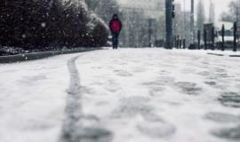 low-angle-shot-person-walking-snow-covered-sidewalk-snow_181624-21806.jpg