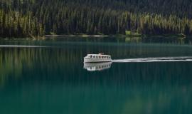 boat-in-the-clear-lake-surrounded-by-green-forest_181624-8931.jpg