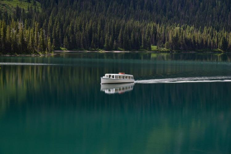 boat-in-the-clear-lake-surrounded-by-green-forest_181624-8931.jpg