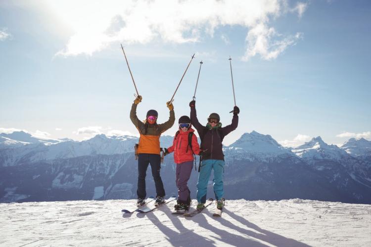 celebrating-skiers-standing-snow-covered-mountain_107420-96438.jpg