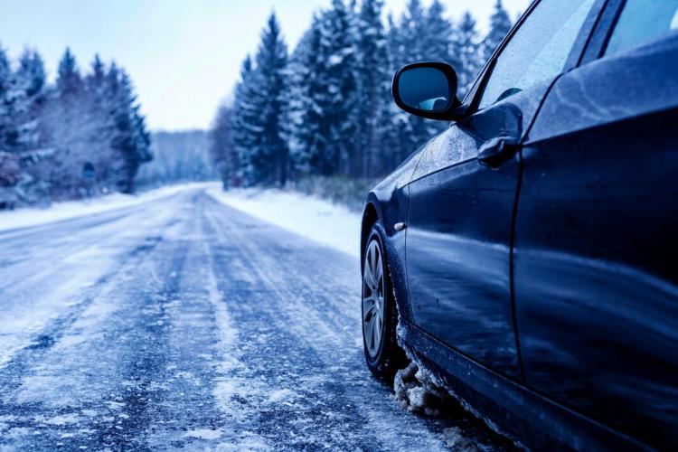 black-car-iced-road-surrounded-by-trees-covered-with-snow_181624-42123.jpg