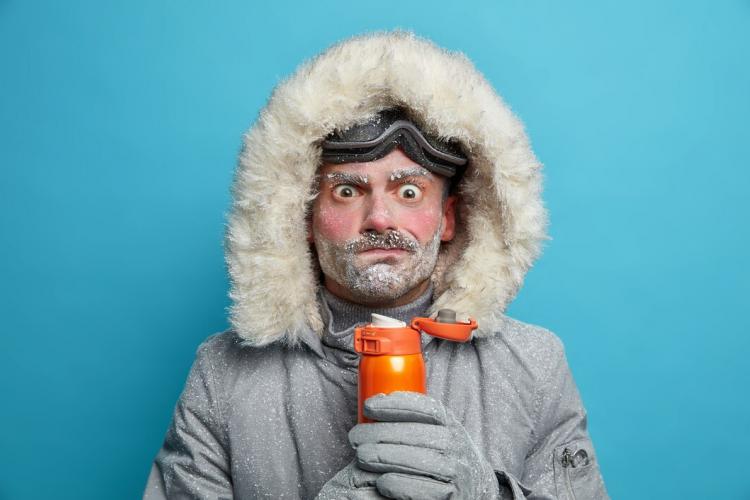 puzzled-frozen-man-winter-clothes-tries-warm-himself-with-hot-beverage-has-red-face-bear-covered-with-blizzard-spends-much-time-outdoors-during-snowboarding-frosty-weather-conditions_273609-47051.jpg