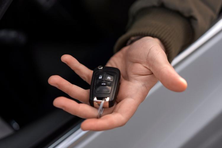 high-angle-hand-holding-car-key_23-2150320964.jpg