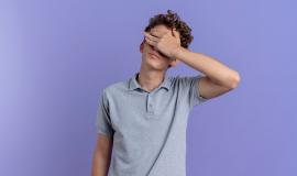 young-man-black-glasses-wearing-grey-polo-shirt-covering-eyes-with-hand-tired-bored-standing-blue-wall_141793-57512.jpg