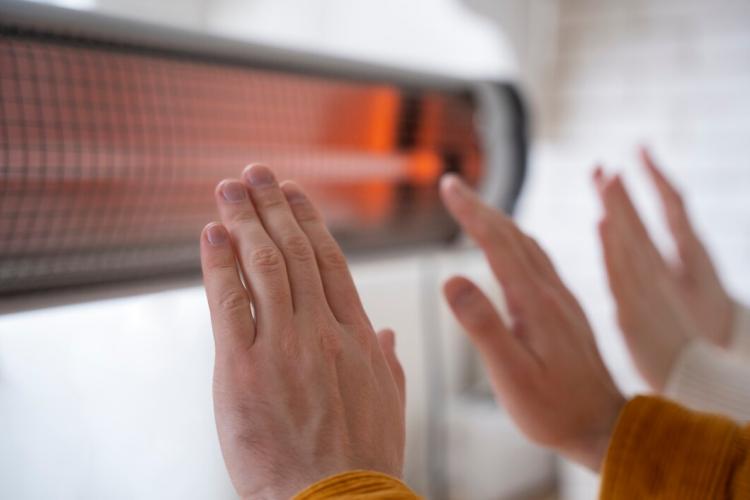 close-up-people-warming-up-hands-near-heater_23-2149339533.jpg