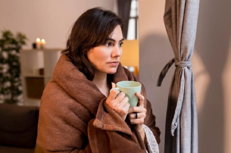 woman-holding-cup-coffee-while-being-covered-with-blanket_23-2148821621.jpg