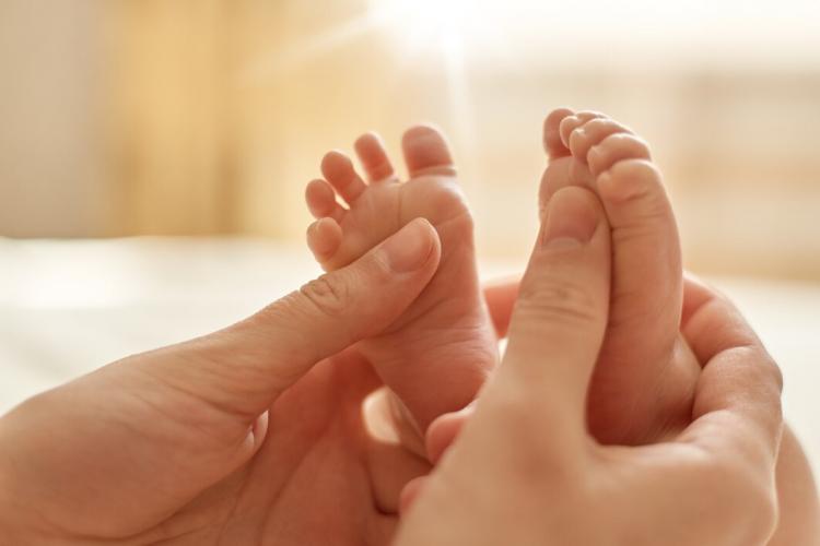 mum-making-baby-massage-mother-massaging-infant-bare-foot-preventive-massage-newborn-mommy-stroking-baby-s-feet-with-both-hands-light-background_176532-13965.jpg